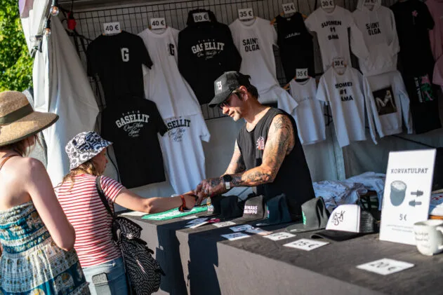 Selling some merchandise. Photo: Timo Uimi / Ilosaarirock 2025
